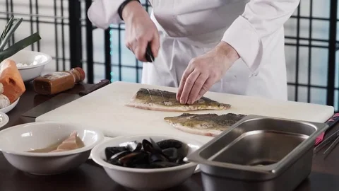 Proseffional chef hands is cutting Fish on his own modern kitchen in slow motion Stock Footage 73213364
