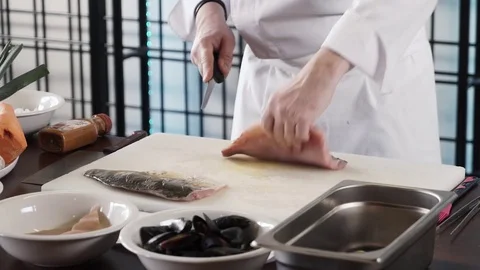 Proseffional chef hands is cutting Fish on his own modern kitchen in slow motion Stock Footage 73213588