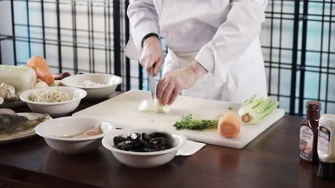 Proseffional chef hands is cutting Onion on his own modern kitchen in slow Stock Footage 73211359