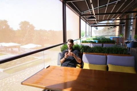 Prosperous man using smartphone for conversation an power bank a Foto stock