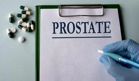PROSTATE - word on a white sheet on the background of a hand in a blue glove Stock Photos