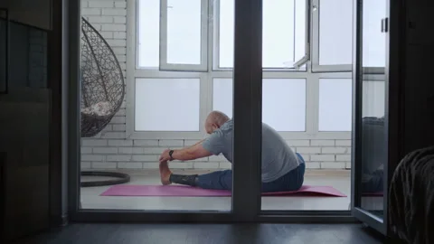 Prosthetic Leg User Performing Stretching on Yoga Mat Stockbeeldmateriaal 317972963