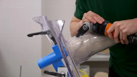 Prosthetic technician cutting custom leg socket with power tool Vídeo Stock 334137087