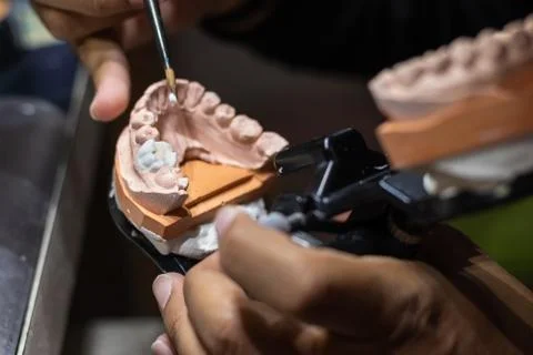 Prosthetic tooth being modeling with ceramic powder Stock Photos