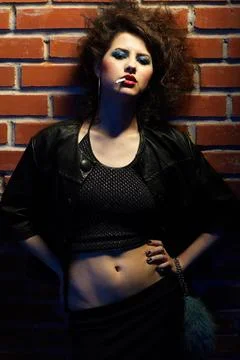 Prostitute portrait of girl dressed like hooker posing near brick wall Cop... Stock Photos