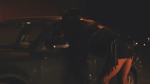 Prostitute talking with client on the street at night. Transgendered prostitute Stock Footage 122589161
