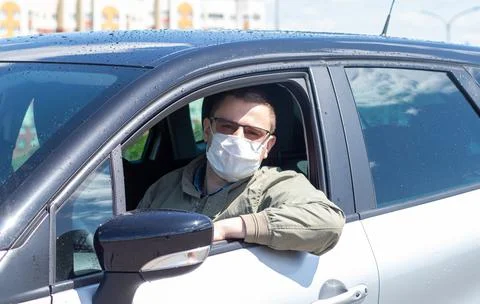 Protect yourself from the coronavirus with a mask while driving Stock Photos