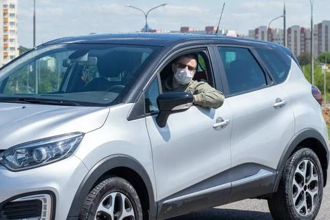 Protect yourself from the coronavirus with a mask while driving Stock Photos