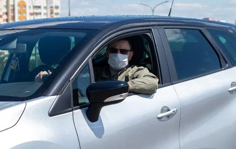 Protect yourself from the coronavirus with a mask while driving Stock Photos