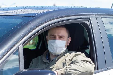 Protect yourself from the coronavirus with a mask while driving Stock Photos