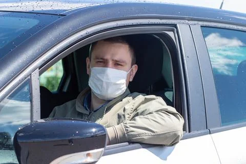 Protect yourself from the coronavirus with a mask while driving Stock Photos