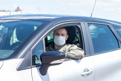 Protect yourself from the coronavirus with a mask while driving Stock Photos