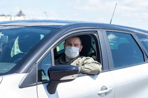 Protect yourself from the coronavirus with a mask while driving Stock Photos