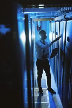 Protecting our data from thieves. a young man working in an IT server room. Stock Photos