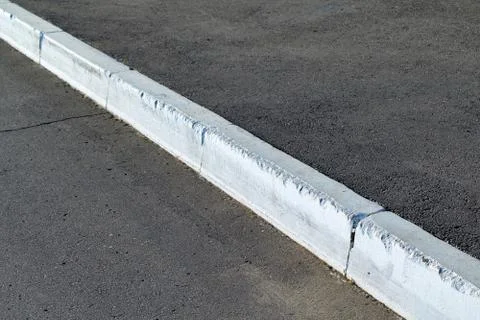 Protective border between asphalt road and pavement. Stock Photos