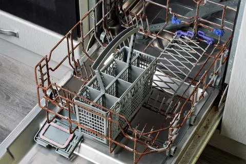 Protective coating of dishwasher rack has cracked and peeled, exposing rusted Stock Photos