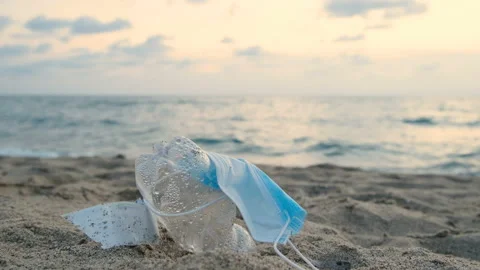 Protective face mask and plastic bottle discarded on marine ecosystem,pollution Stock Footage 161909537