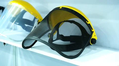 A protective face shields with a black mesh visor and yellow headbands disp.. Stock Photos