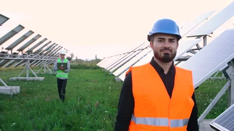 Protective helmet engineer who walks on the field of the solar panel and looks Video stock 140206550