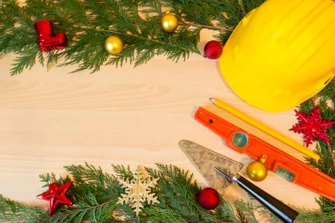 Protective helmet, mason tools  and Christmas decorations on wooden backgroun Stock Photos