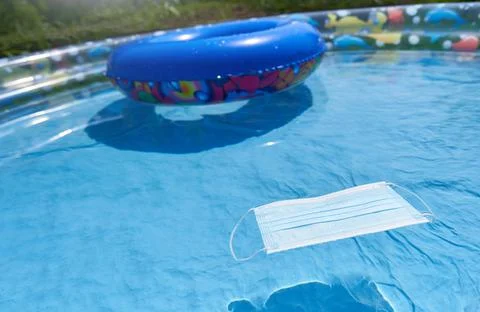 Protective mask in a children's inflatable pool, the concept of a seaside Stock Photos