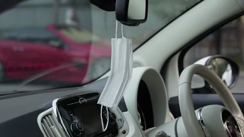 The protective mask hangs on the rearview mirror in the car Stock-Footage 143458543