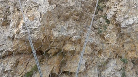 Protective nets are used to protect mountain trails from rockfall Stock Footage 249384448