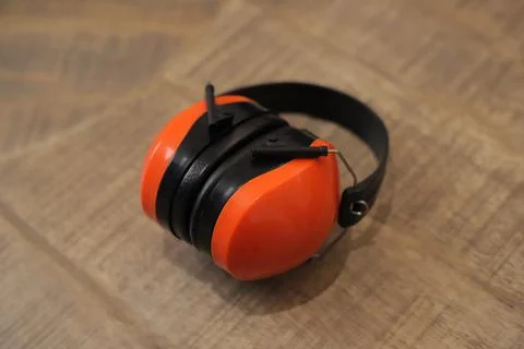 Protective orange earmuffs on the table 库存照片