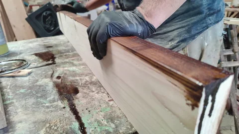 Protective Paint is Applied to Wood Planks in the Carpentry Shop Stock Footage 304925857