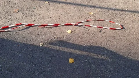 The protective red and white tape is torn off and lying on the road Stock Footage 161023886