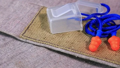 Protective working burlap gloves and earplugs on rotating surface. Stock Footage 70826187
