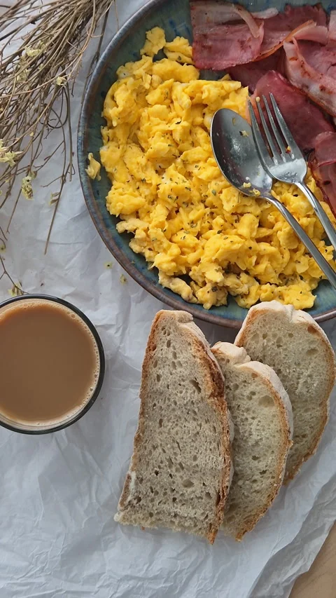 Protein breakfast with scrambled eggs, bacon, bread and coffee Stock Footage 340331611
