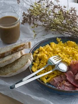 Protein breakfast with scrambled eggs, bacon, bread and coffee Stock Photos
