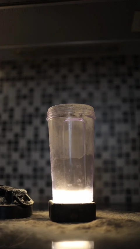 Protein powder falling into shaker in moody kitchen light Stock Footage 329449533