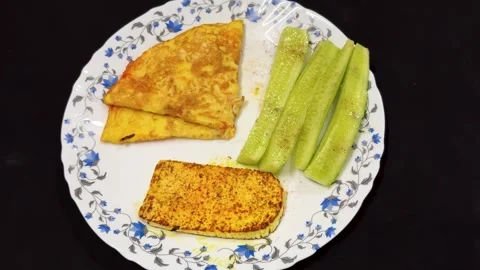 Protein rich breakfast featuring omelette paneer steak and cucumber sticks .. Stock Footage 336149324
