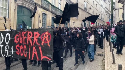 Protest March With Black Flags And Banner Across Historic Lisbon Street Stock Footage 325867343