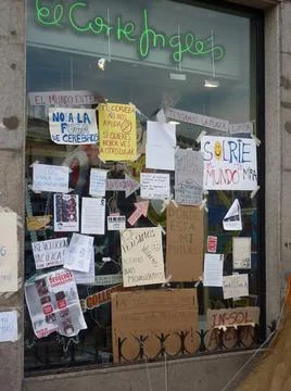 Protest placards pasted on a store window. 15M Stock Photos
