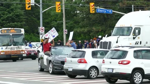 Protest starting to take over large intersection during regular traffic hours Stock Footage 133975459