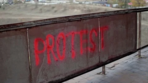 Protester goes out after making protest graffiti with red spray paint Stock Footage 143349011