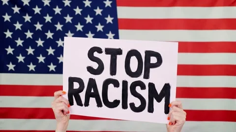 Protester holds a banner with a slogan - Stop Racism - against background of the Stock Footage 132002125