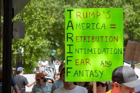 Protester holds sign criticizing tariffs at Atlanta Hands Off march Stock Photos