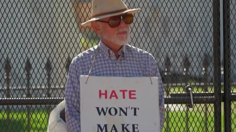 A protester holds a sign reading Hate Won't outside the White House Stock-Footage 345299496