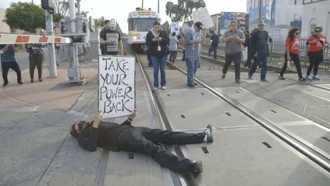 Protester lies in the middle of train tracks Video stock 81801606