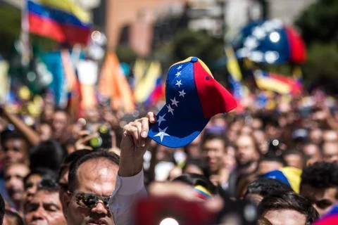 Protester lifts tricolor cap in protest at march in Caracas, Venezuela Stock Photos
