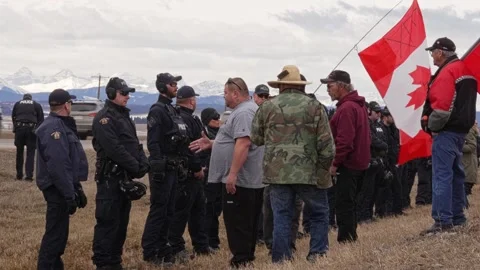 Protester trying to shake hands with RCMP - Cochrane, Alberta: April 2, 2024 Stock Footage 270648071