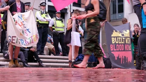 Protester walks through Red Paint and Money at XR Blood Money Protest Stock Footage 160151266