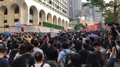 Protester waving US flag and chanting 'Liberate HK, revolution of our times'. Stock Footage 115706520