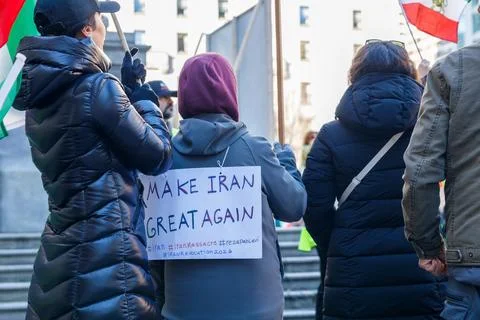 Protester wears sign reading MAKE IRAN GREAT AGAIN with hashtags at Iranian.. Stock Photos