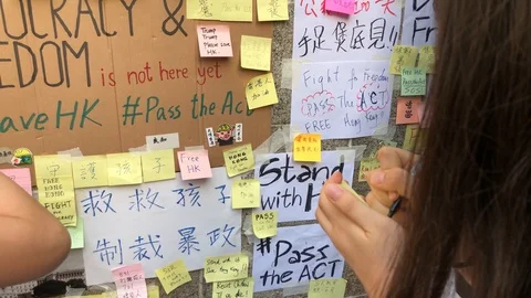Protester writing sticky note outside US consulate. Hong Kong Style Lennon Wall Stock Footage 115706685