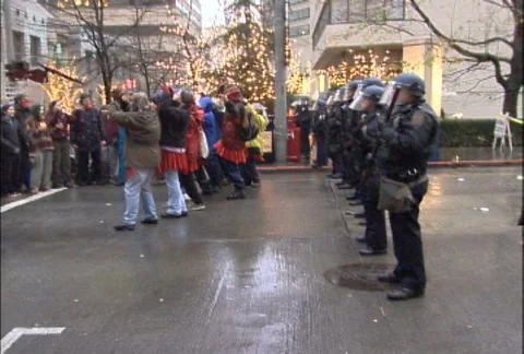 Protesters Dancing and Singing in Front of Police Blockade at WTO Protests Stock Footage 106957860